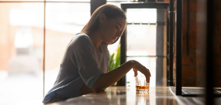 Depressed woman drinking at bar